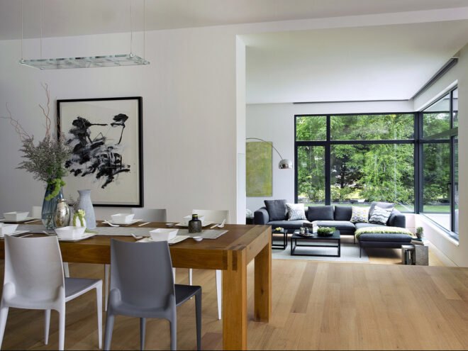 a dining room with a large painting on the wall, a dining table and chairs