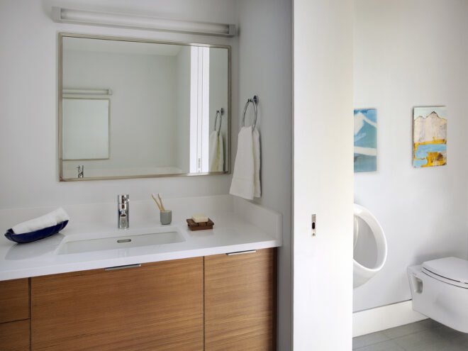 a bathroom with cabinets and mirrors and a toilet on the right