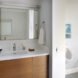 a bathroom with cabinets and mirrors and a toilet on the right