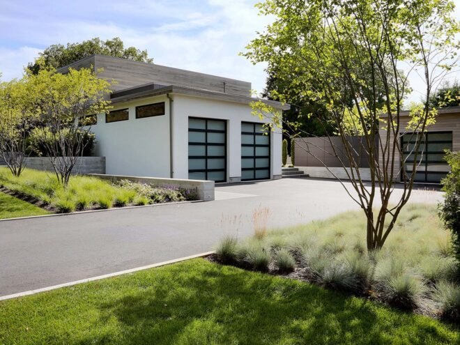 a white garage building surrounded by greenery