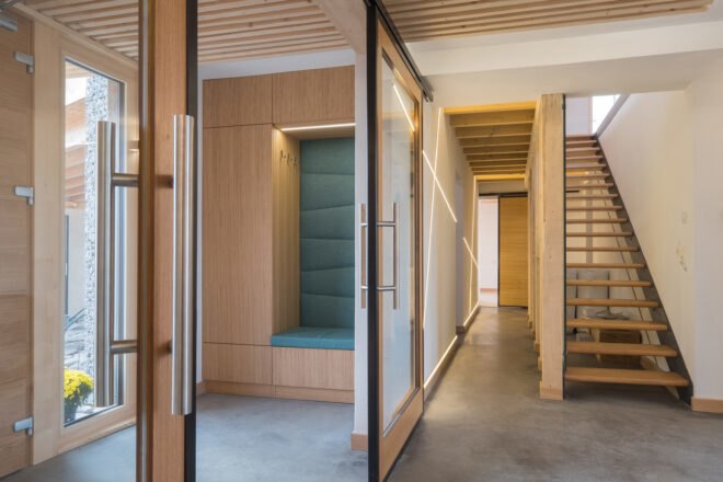 to the left is a doorway leading into an area of the house with a wooden staircase