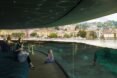 rendering of room with glass walls next to a lake