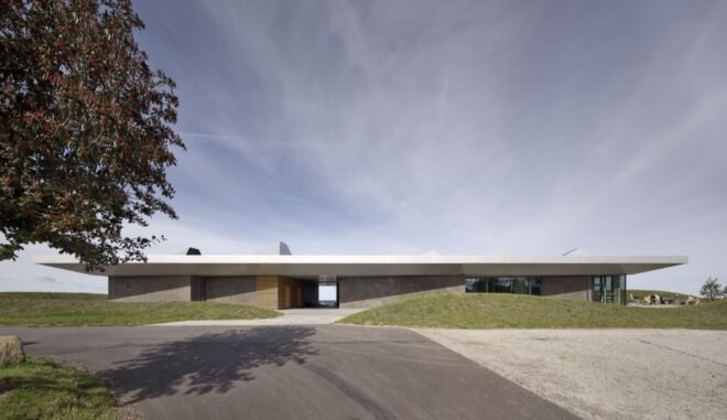 driveway leading to long, flat gray building