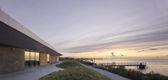 gray and wood building near the sea at dusk