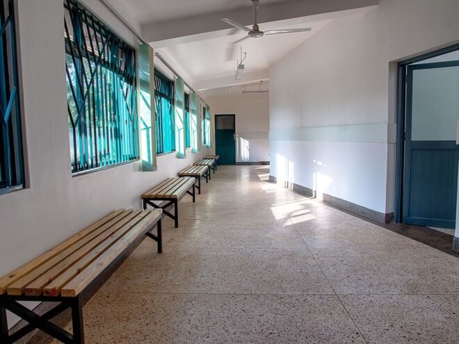 wood benches in white room with blue patterned covers over the windows