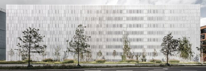 a day-time sideview of a silver, rectangular parking building