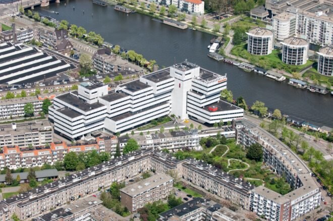 a bird's-eye view of the old Rivierstaete building, showing the city, trees and river