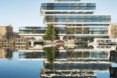 a riverfront view of a tired, glass facade building, which is also reflected in the water