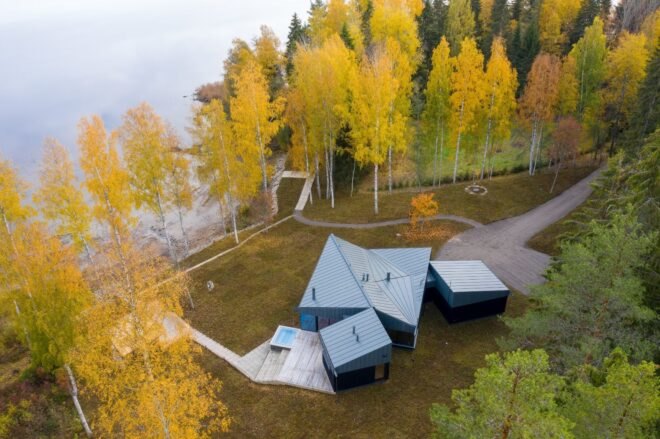 aerial shot of home surrounded by trees and a lake