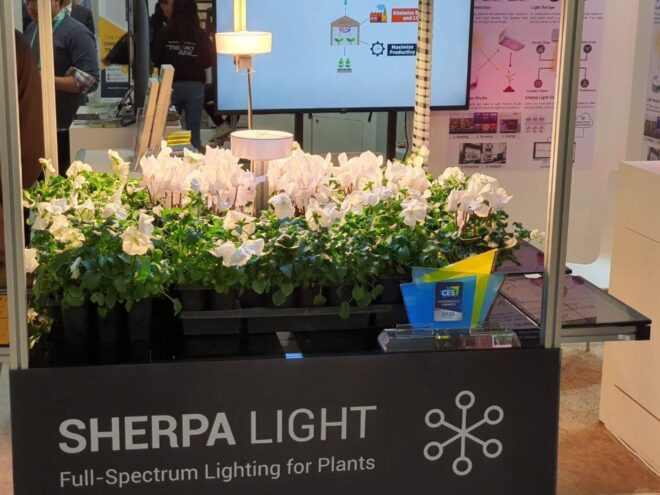 a close-up of the Sherpa Light booth at CES 2020. green plants are mounted on a gray box labeled "Sherpa Light."
