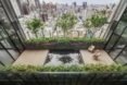 chairs on wood patio by reflective pool with city skyline in the background
