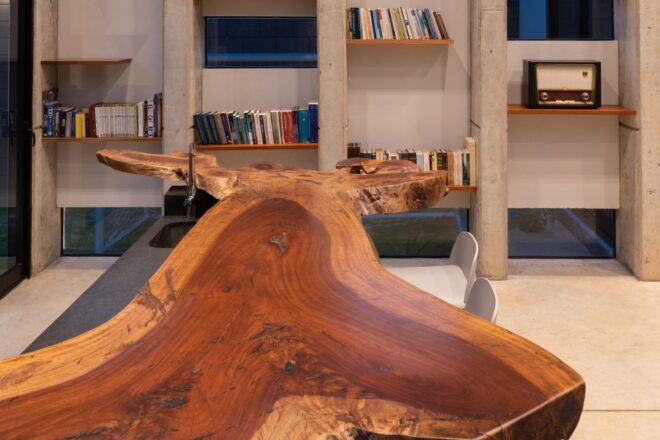 large live edge wood table with bookshelves in the background