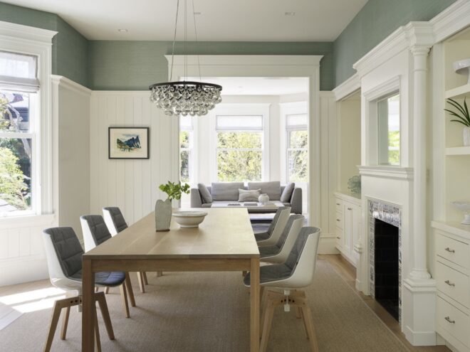 wood dining table with gray chairs in room with sage green and white walls