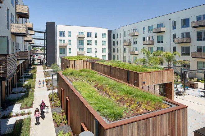 the interior of the housing community with white buildings and wood buioldings with green rooftops