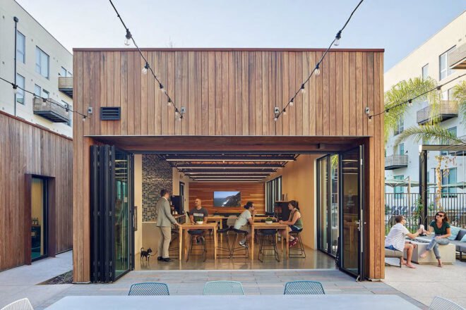 a wood paneled building with people sitting at tables inside