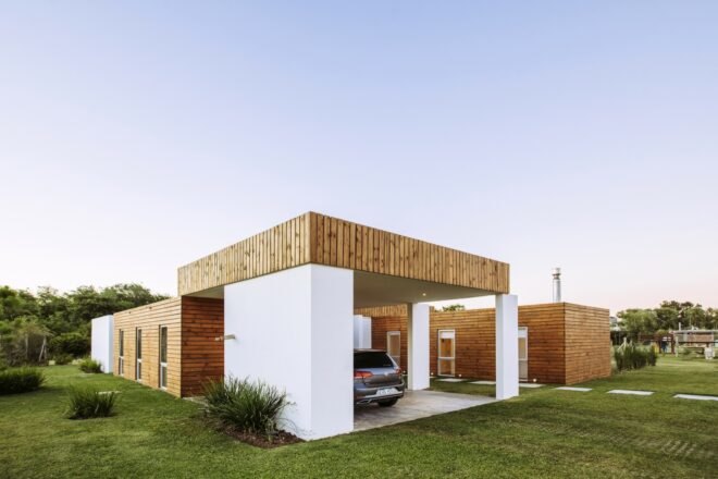 white and wood home with modern car port