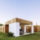 white and wood home with modern car port