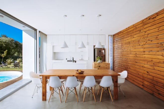 wood dining table with white chairs near white kitchen