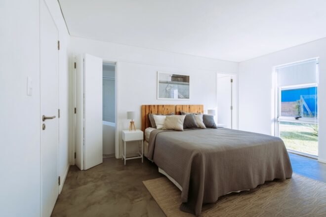 brown bed with wood headboard in white bedroom
