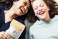 two people laughing and holding kelp jerky