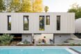 long, narrow wood home beside a rectangular swimming pool