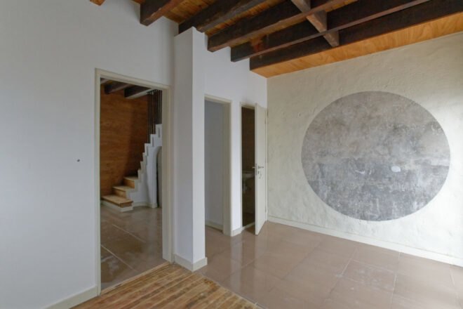 white room with gray round mural on wall