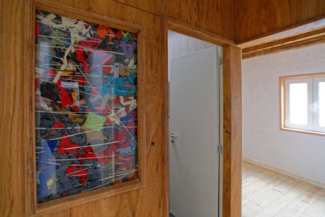 wood wall with glass panel revealing cloth insulation