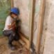 person in hard hat adding insulation to old walls