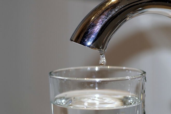water pouring from a faucet into a glass