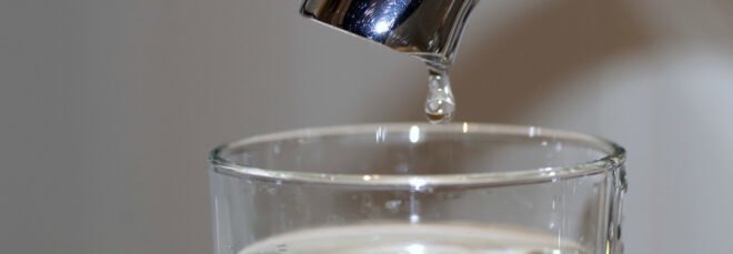 water pouring from a faucet into a glass