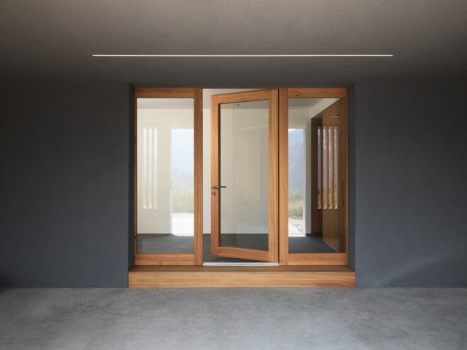 timber-framed glass doors on a concrete wall