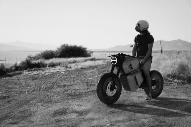 black and white photo of person riding a hybrid motorcycle