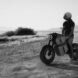 black and white photo of person riding a hybrid motorcycle