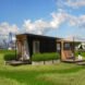 black tiny home with two wood decks on an island