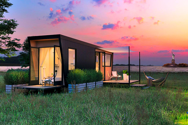 black tiny home with two wood decks on an island during a pink sunset