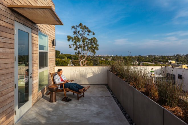 person on lounge chair on apartment balcony