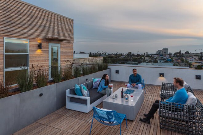 group of friends sitting on sofas on outdoor deck