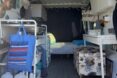 interior space of converted van, showing organizational furniture and a bed towards the back of the van