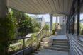 a stairwell open to the outdoors, with lush greenery and sunlight