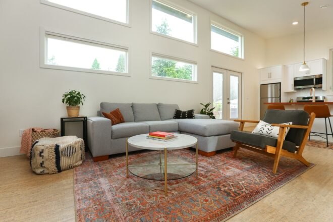 gray sofa, round coffee table and red patterned rug