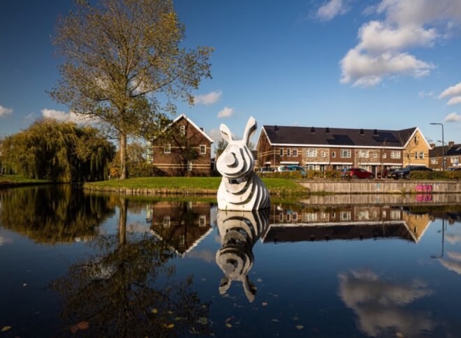 gray 3d-printed rabbit sculpture in a pond