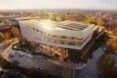 solar panels reflecting sunlight atop a large white college building