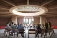rendering of people sitting in a circle under a round skylight