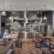 a communal kitchen area with steel and people lounging