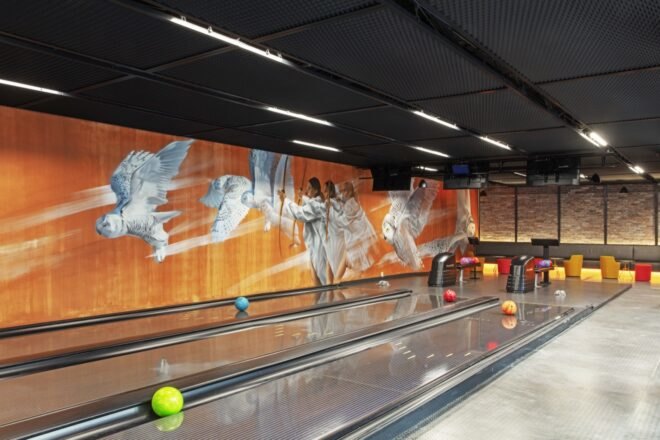 a bowling alley with an orange and white mural on the wall