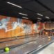 a bowling alley with an orange and white mural on the wall