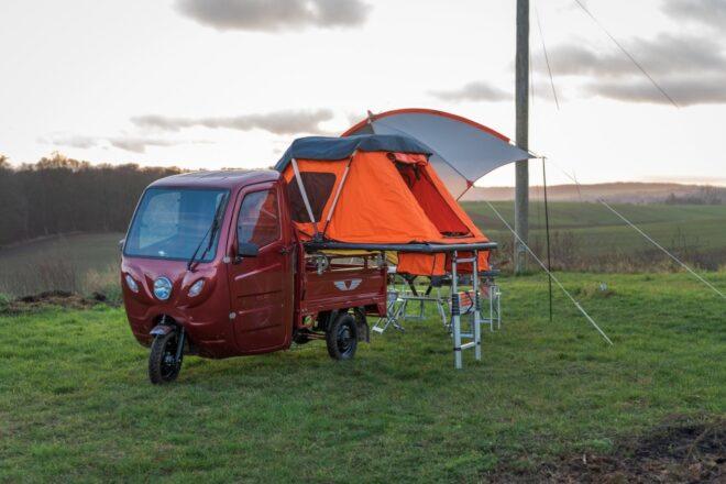 Little red vehicle with tent folded out to the side