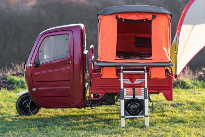 Side view of camper with orange tent