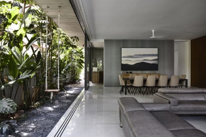 open-plan living room with gray sofa and a wall open to the outdoors