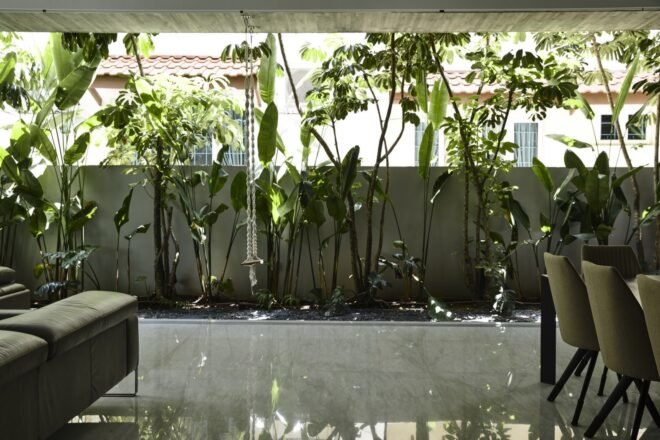 couch and dining table beside open wall facing plants